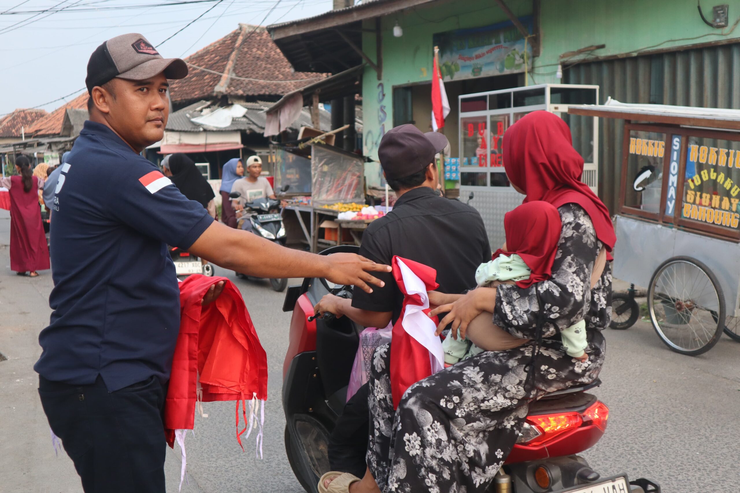 MENYAMBUT HUT RI KE-80, DPK KNPI MEKAR BARU BAGIKAN RATUSAN BENDERA MERAH PUTIH KEPADA WARGA